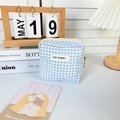 Detail van een hemelblauw geblokte opbergzak voor maandverband met rits en stoffen label - Blauw Geruit