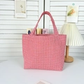 Detail of red and white checkered canvas handbag in a bright indoor lifestyle setting - Small Grid Bright Red