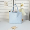 Detail of blue and white checkered canvas tote bag on a white table in minimalist setting - Blue Gingham