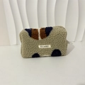 Dettaglio della trousse in pile con motivi a contrasto blu e marroni e cerniera - Cane di peluche