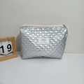 Macro shot of silver quilted PU leather makeup bag with woven texture and white woven label - Silver Small Grid