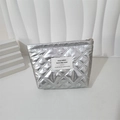 Close-up of silver quilted makeup bag with heart pattern on a minimalist white display - Silver Rhombic Pattern