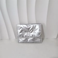 Detailansicht der silbernen Stepptasche mit 3D-Schleifenmuster und Druckknopfverschluss - Mini-Schleifenhalskette / Silber