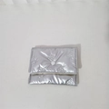 Detail of silver metallic quilted clutch with bow embossing and white snap button closure - Mini Bowknot Necklace / Silver