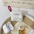 Detailed macro view of a white quilted silk-texture case for AirPods with a pink lanyard - Off-white Heart