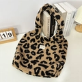 Dettaglio della borsa tote in peluche maculata con etichetta tessuta sulla scrivania - Peluche Kaki Grande Leopardo