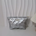 Detail der silbernen gesteppten Kosmetiktasche mit Schleifenmuster und Goldreißverschluss - Kleine Schleife Silber