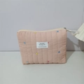 Detailed view of pink quilted cosmetic bag featuring colorful heart embroidery and zipper - Pink Heart Embroidered Clutch