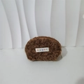 Detail of a brown plush mini bag showing curly faux fur texture and brand label - Maillard Brown
