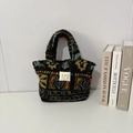Dettaglio della borsa tote in peluche con motivi geometrici e logo del marchio - Plaid foglia d'acero