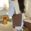 Gros plan du sac seau en peluche marron foncé montrant la texture douce et l'étiquette - Brun Maillard