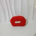 Close-up of a red plush shell pouch with a top zipper and a mayrabbit logo woven label - Bright Red