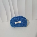 Close-up of blue plush shell bag showing soft fuzzy texture and zipper closure - Blue