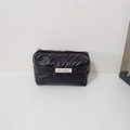 Close-up of black quilted makeup bag with butterfly embossing and May Rabbit woven label - Small Bow Black