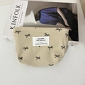 Détail de la trousse de maquillage en velours côtelé avec broderie nœud papillon - Petit sac à rouge à lèvres blanc cassé avec nœud