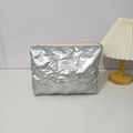 Macro detail of silver quilted PU makeup bag with embossed bow patterns and zip closure - Small Bow Silver