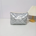 Macro detail of quilted silver makeup bag with square label and metal zipper closure - Bubble Quilted Silver