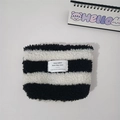 Close-up of black and white striped plush cosmetic bag with a branded cloth label - Black & White Stripes