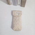Detail van crème gewatteerde brillenkoker met hartvormige stiksels en regenboog logo-label - Khaki Hart
