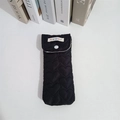 Close-up of heart quilted black eyewear pouch with press stud and woven logo tag - Black Heart