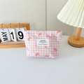 Detail of pink plaid canvas cosmetic bag with bow patterns and silver zipper on white desk - Checkered Print Bow Pink