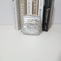 Detailed view of silver quilted PU cosmetic bag with heart-shaped texture and brand label - Silver Heart