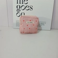 Macro detail of pink quilted fabric with red hearts and a zipper on a vanity pouch - Pink Square Bag