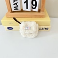Custodia in peluche bianca per auricolari con cinturino su sfondo di libri gialli - Peluche Teddy Bianco Riso