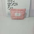 Close-up of pink quilted cosmetic bag with red heart pattern and silver zipper detail - Pink Lipstick Bag