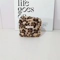 Dettaglio della borsa in sherpa leopardato con etichetta May Rabbit su scrivania bianca - Stampa leopardata marrone