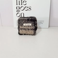 Detail of plush marble pattern square pouch featuring a zipper and white woven label - Black Grey Plaid Sherpa