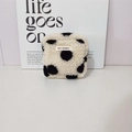 Dettaglio della borsa in peluche con stampa mucca, texture morbida e logo - Pois Neri