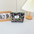Detailed close-up of blue canvas cosmetic bag with pink tulip print in home setting - Floral Tulip Black