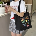 Détail d'un sac cabas en toile noire avec motifs brodés colorés d'animaux et fleurs - Sac Bandoulière Cordon Broderie Éponge Mignon : Petite Fleur Hirondelle (Noir)