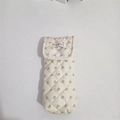 Close-up of quilted floral fabric case with snap button and diamond stitching pattern - White Base Floral
