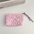 Detail of pink quilted heart pouch with a cream zipper and May Rabbit brand label - Pink