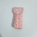 Detailed close-up of pink quilted fabric texture with red hearts and white snap button - Pink Glasses Bag