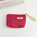 Close-up of heart-quilted rose red makeup pouch with yellow woven zipper pull - Burgundy