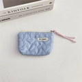 Macro shot of light blue quilted heart pouch with MAY RABBIT tag and pink zipper puller - Blue