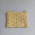 Close-up of the heart quilted pattern and zipper detail on the yellow storage bag - Yellow