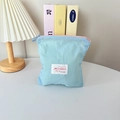Close-up of a light blue macaron mini cosmetic bag with pink zipper and branded tag - Vertical Style / Blue