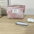 Detailansicht der rosa gesteppten Kosmetiktasche mit großer Schleife und Stoffetikett - Rosa Hintergrund Schleife