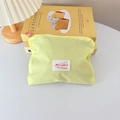 Close-up of yellow fabric cosmetic bag with red brand label and pink ring zipper handle - Horizontal Style / Yellow