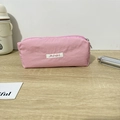 Detailed view of pink fabric pencil case with Mayrabbit label on a wooden desk - 19x6x7cm / Pink