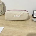 Close-up of Mayrabbit macaron pencil case with purple zipper on a wooden desk - 19x6x7cm / Khaki