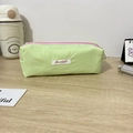 Detail of macaron green pencil case with pink zipper on light wooden desk - 19x6x7cm / Green