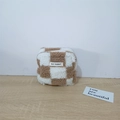 Detail of the soft plush checkerboard pouch with May Rabbit label on wooden table - Plush Khaki Checkerboard