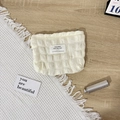 Makro-Detail der beigefarbenen Waffel-Kosmetiktasche mit Reißverschluss-Detail - Blasenbeige