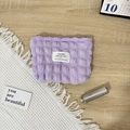 Detail view of purple bubble textured canvas cosmetic bag with zipper and woven label - Bubble Purple