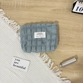 Detail der hellblauen Make-up-Tasche mit Blasenstruktur auf Holztisch in weichem Stil - Blasenblau